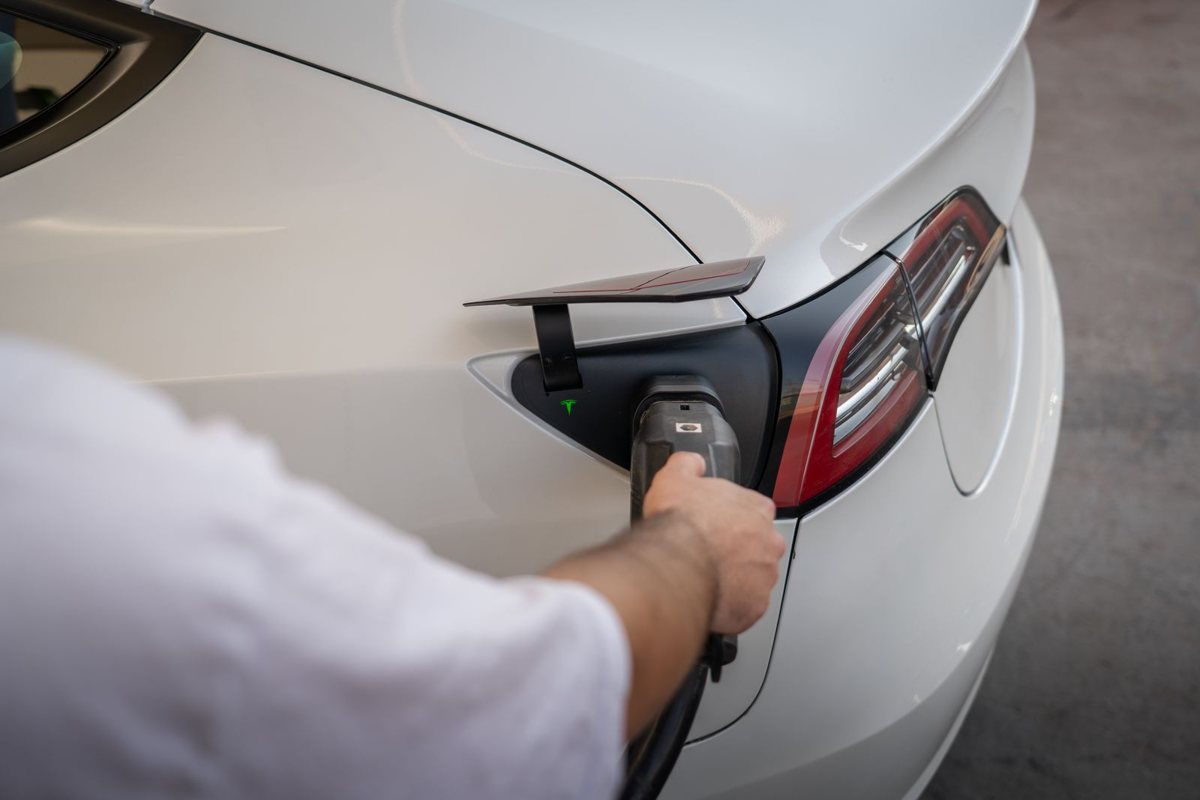 Een elektrische wagen wordt thuis aan de laadpaal gestoken